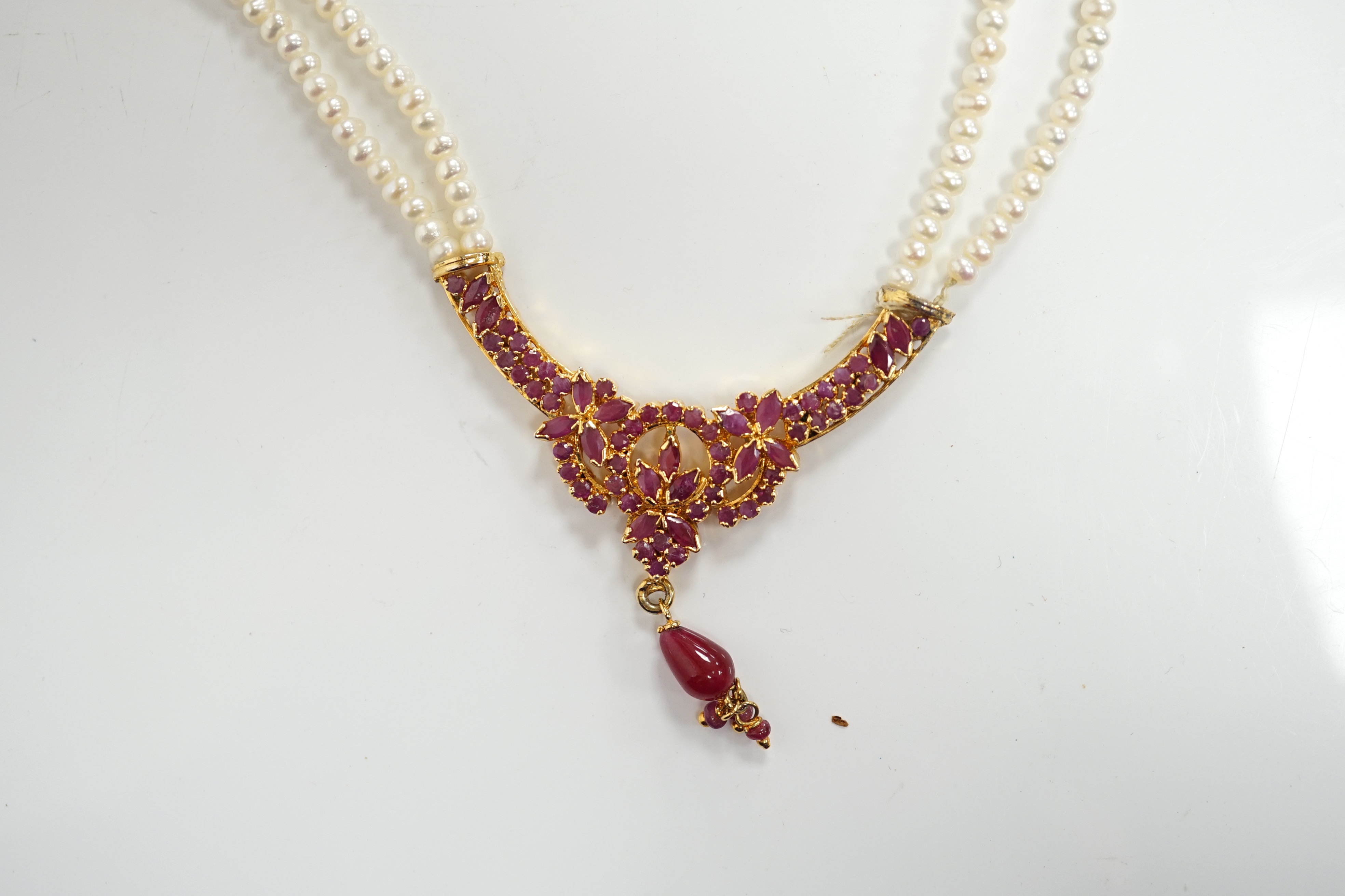 A recent Indian gilt metal and freshwater pearl and ruby cluster set twin strand necklace, 46cm and a pair of matching drop earrings. Condition - fair to good